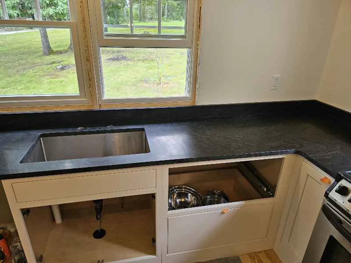 Dark honed granite countertop with undermount sink cutout and white cabinets — fabricated by Precision Granite Works NH