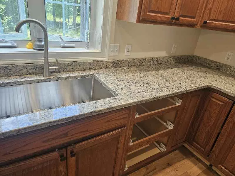 Granite countertops with natural variation beside warm wood cabinets