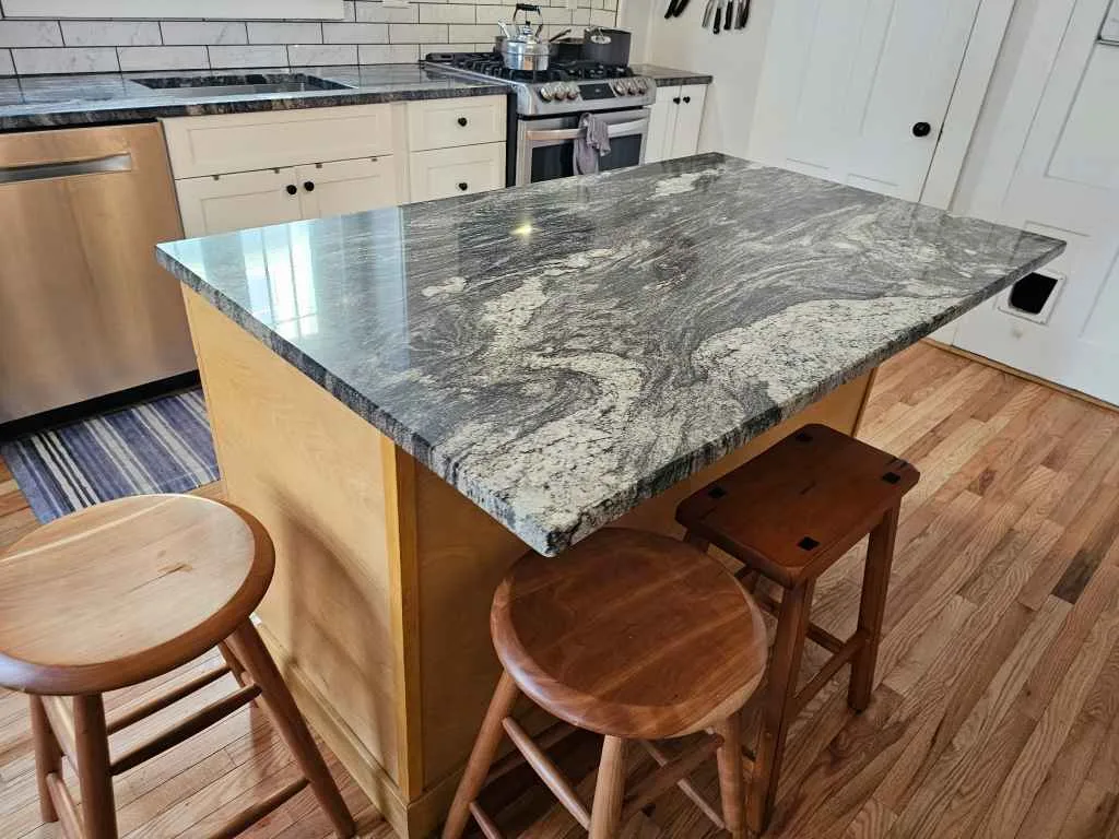 Granite kitchen island with bar stool seating in a busy family home in Concord, New Hampshire