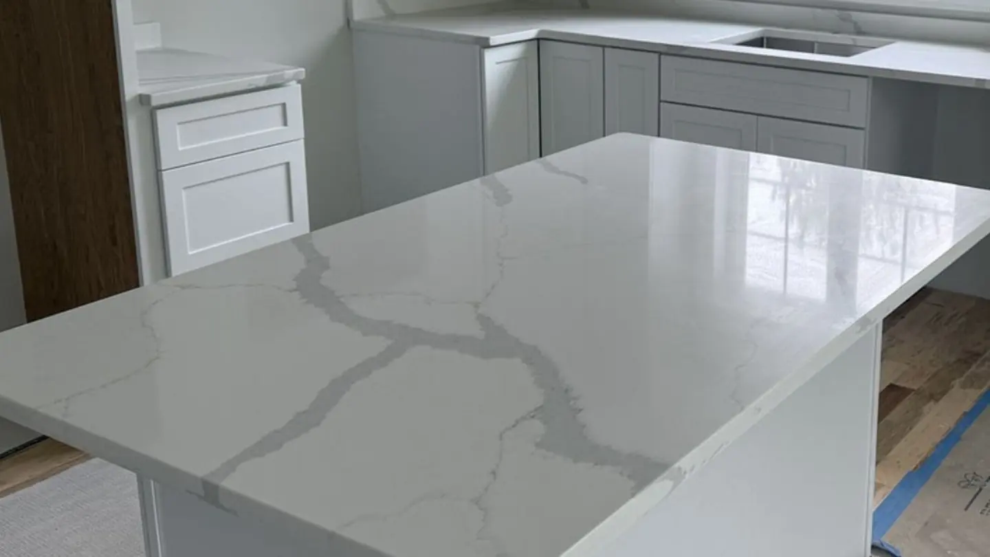 Quartz countertop island with Calacatta-style grey veining in a New Hampshire kitchen