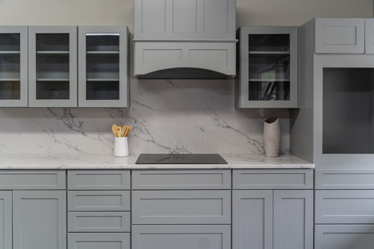 White quartz kitchen countertop with matching full-height quartz backsplash and gray veining