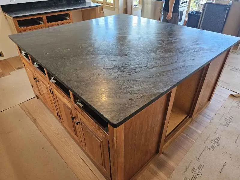Large soapstone kitchen island showing natural surface movement and developing patina