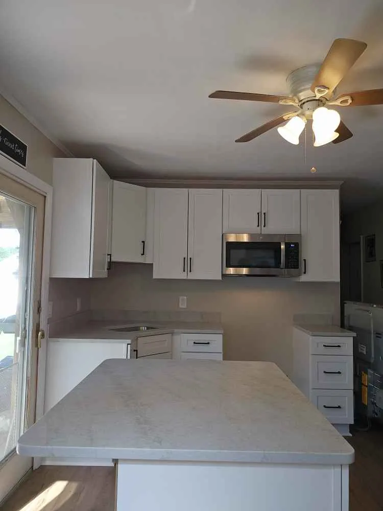 Taj Mahal quartzite countertops with white shaker cabinets and black hardware — installed by Precision Granite Works in New Hampshire