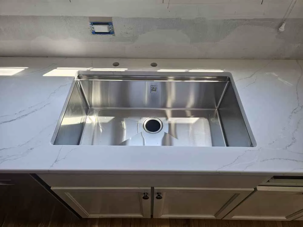 Large single-bowl undermount sink installed in a white stone countertop in Nottingham, NH