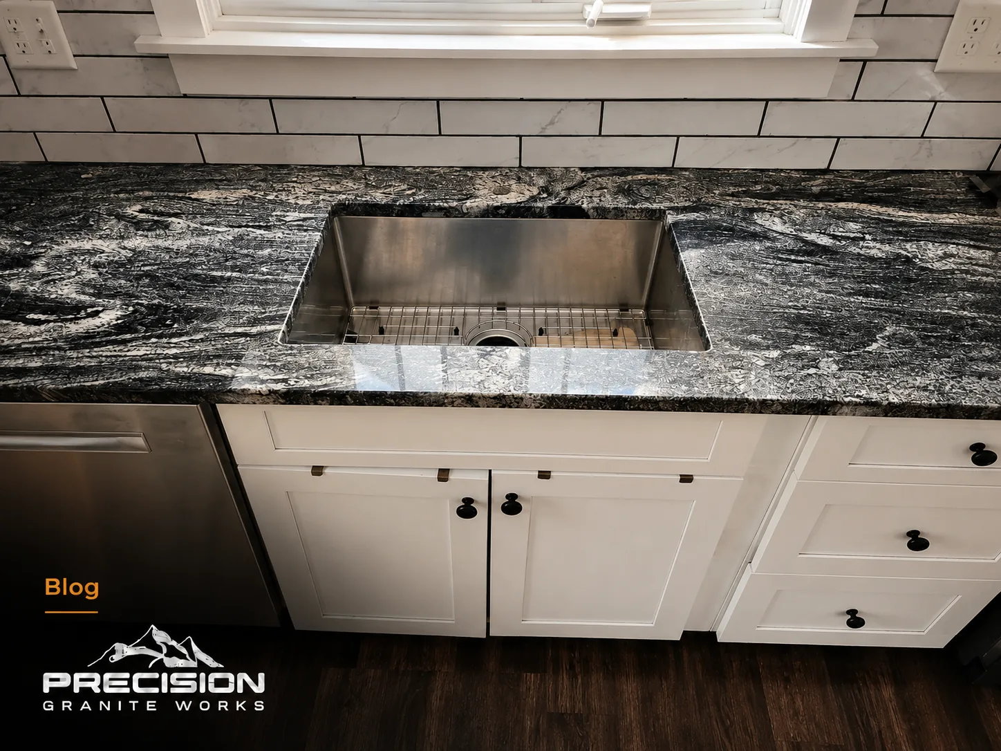 Undermount sink installed in a granite countertop showing the polished stone edge around the sink opening