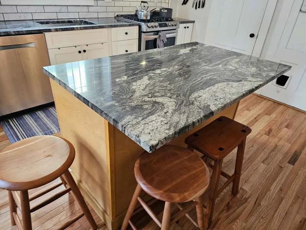 Custom granite island countertop with dramatic veining fabricated by Precision Granite Works in Concord, NH