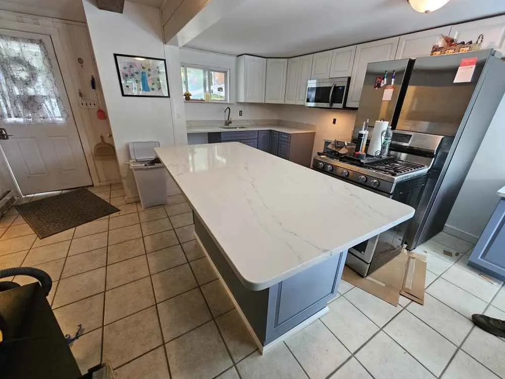 White kitchen island countertop with softly rounded outside corners above a gray cabinet base