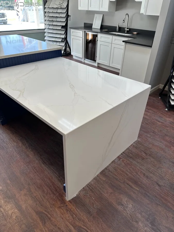 Close view of a white quartz waterfall edge with veining aligned across the mitered corner