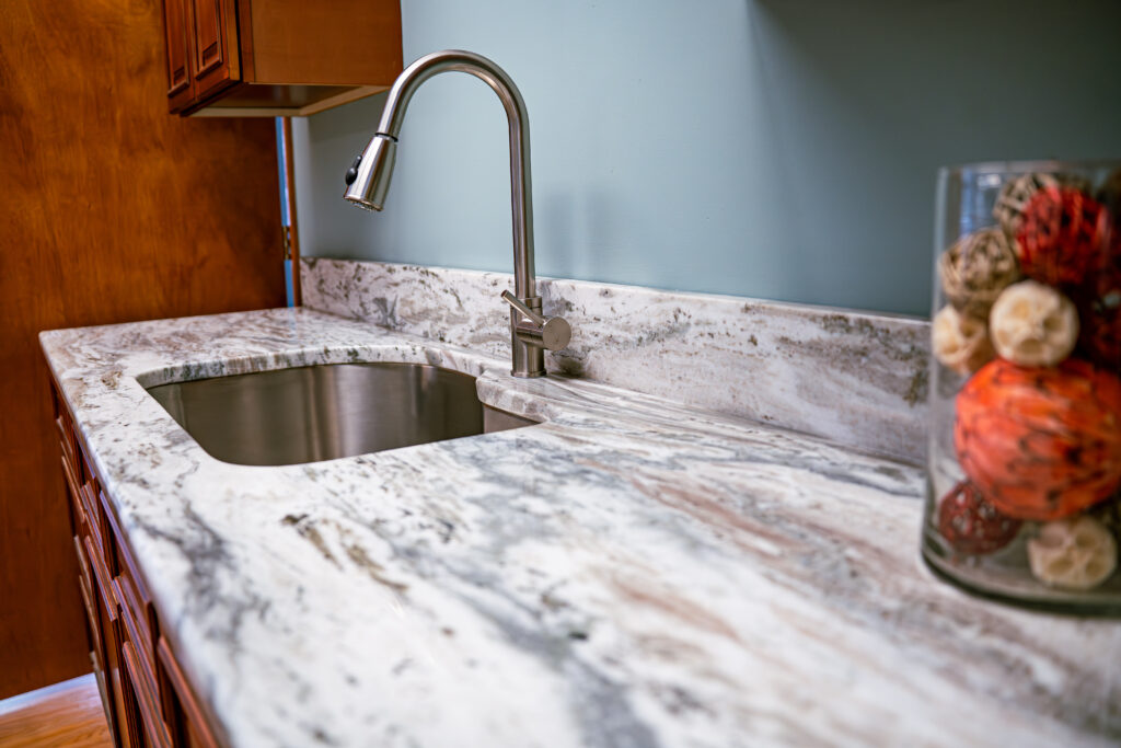 A grey marble countertop with stainless steel metal faucet.