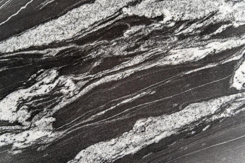 A swatch of granite, marble, quartz that is black with white and grey stripes.