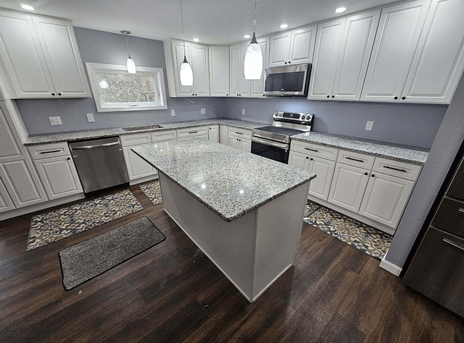 A newly installed kitchen countertop in a sleek grey kitchen and stainless steel appliances.