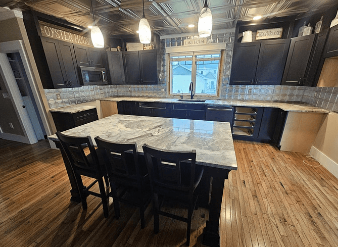A sleek grey island counter in front of a kitchen with a matching grey countertop.